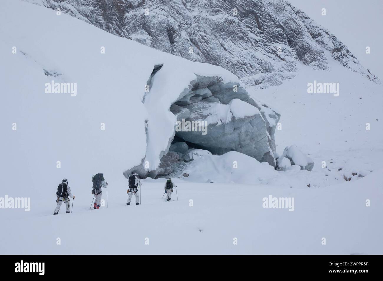 Members of the U.S. Special Operations Mountain Warfare Training Center (SOMWTC) and Danish Special Operation Forces (DANSOF) trek up the mountains of Mestersvig, Greenland, March 6, 2024. The SOMWTC and DANSOF exchanged Arctic best practices during Arctic Edge 24 (AE24). AE24 provided Special Operations Command North and U.S. Special Operations Forces the opportunity to integrate with SOF from Norway, Denmark, and the United Kingdom as well as interagency and total force partners to enhance integrated deterrence, layered defense, and resilience across the Arctic. (U.S. Army photo by Spc. Andr Stock Photo