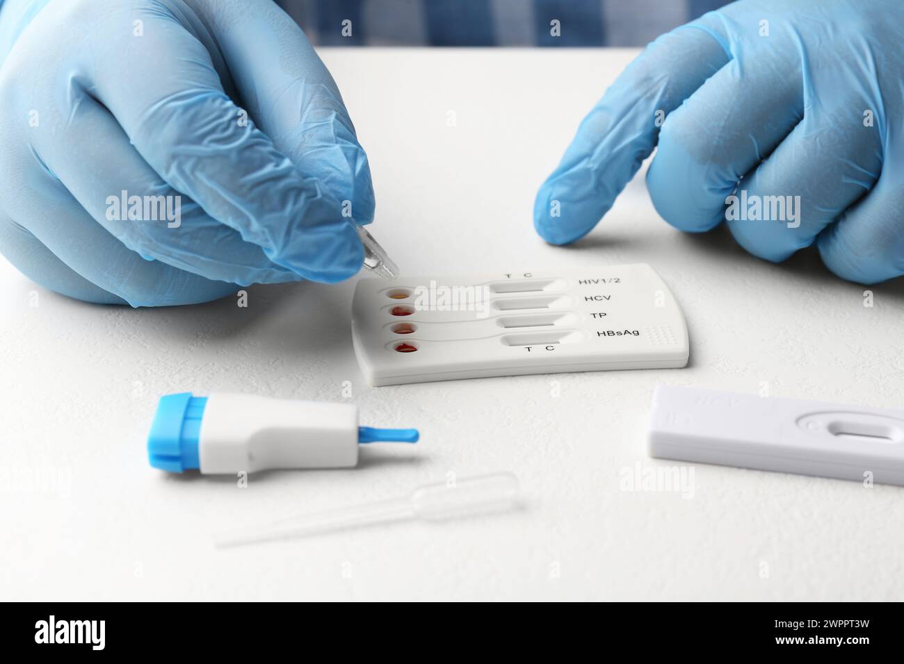 Doctor dropping buffer solution onto disposable multi-infection express ...