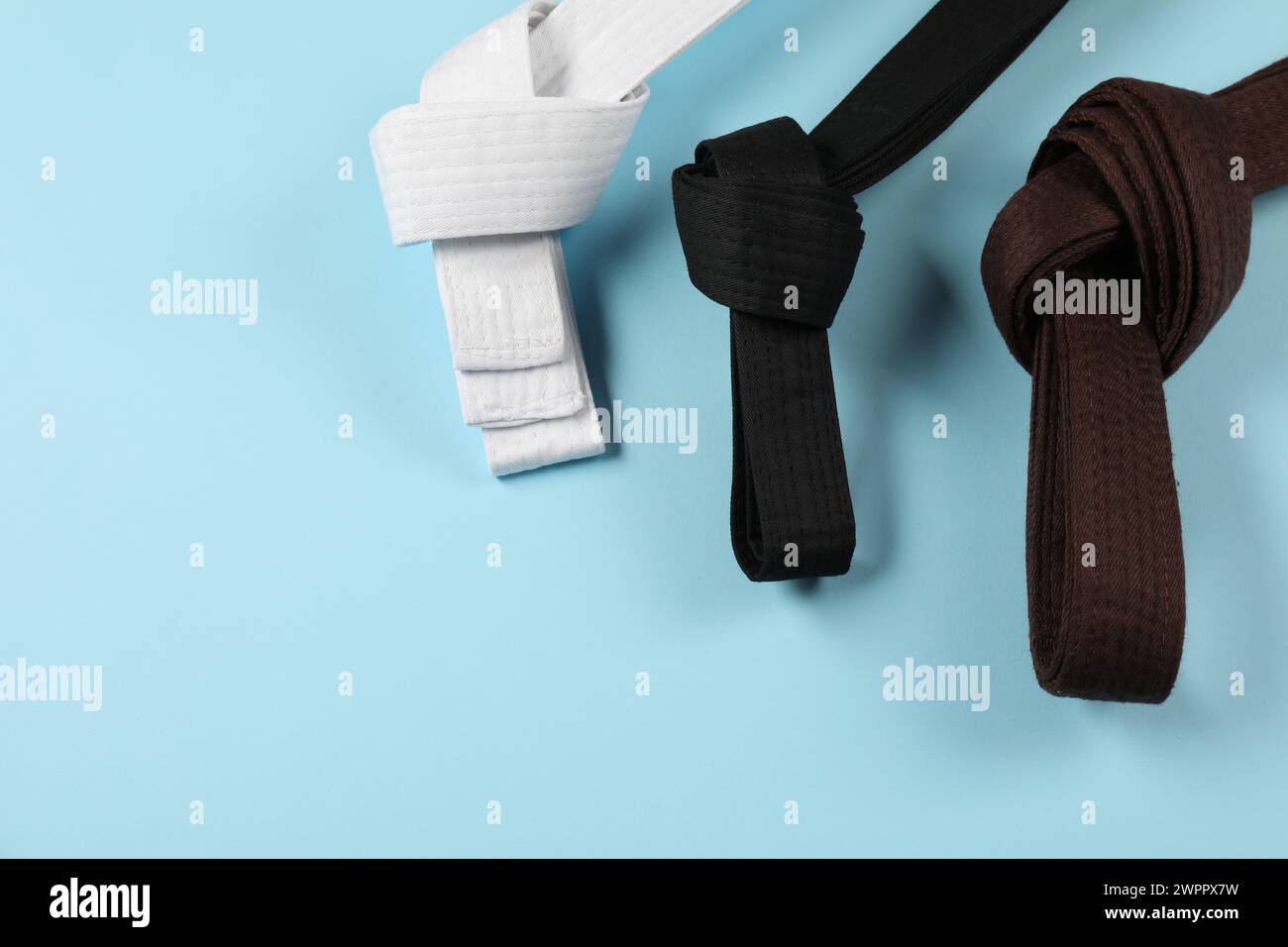 Karate belts on light blue background, flat lay. Space for text Stock ...