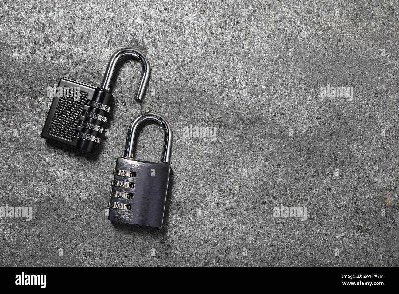 Steel combination padlocks on grey table, top view. Space for text Stock Photo