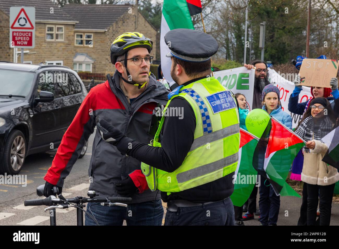 Bingley, UK. 08 MAR, 2024. A hostile parent is spoken to by police after getting into a tense situation with a pro palestinian protestor. Story: Parents of students at Cottingley Village Primary School pulled their children out at 2PM on the 8th of march as part of a co-ordinated strike effort across multiple different schools across Yorkshire for Palestine. Credit Milo Chandler/Alamy Live News Stock Photo