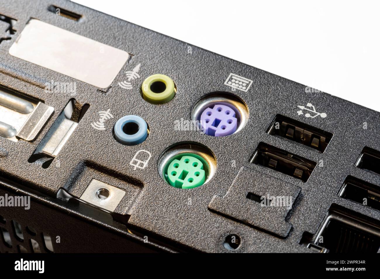 Close-up view of a computer motherboard featuring old obsolete no longer used PS 2 ports for keyboard and mouse along with USB connections old technol Stock Photo