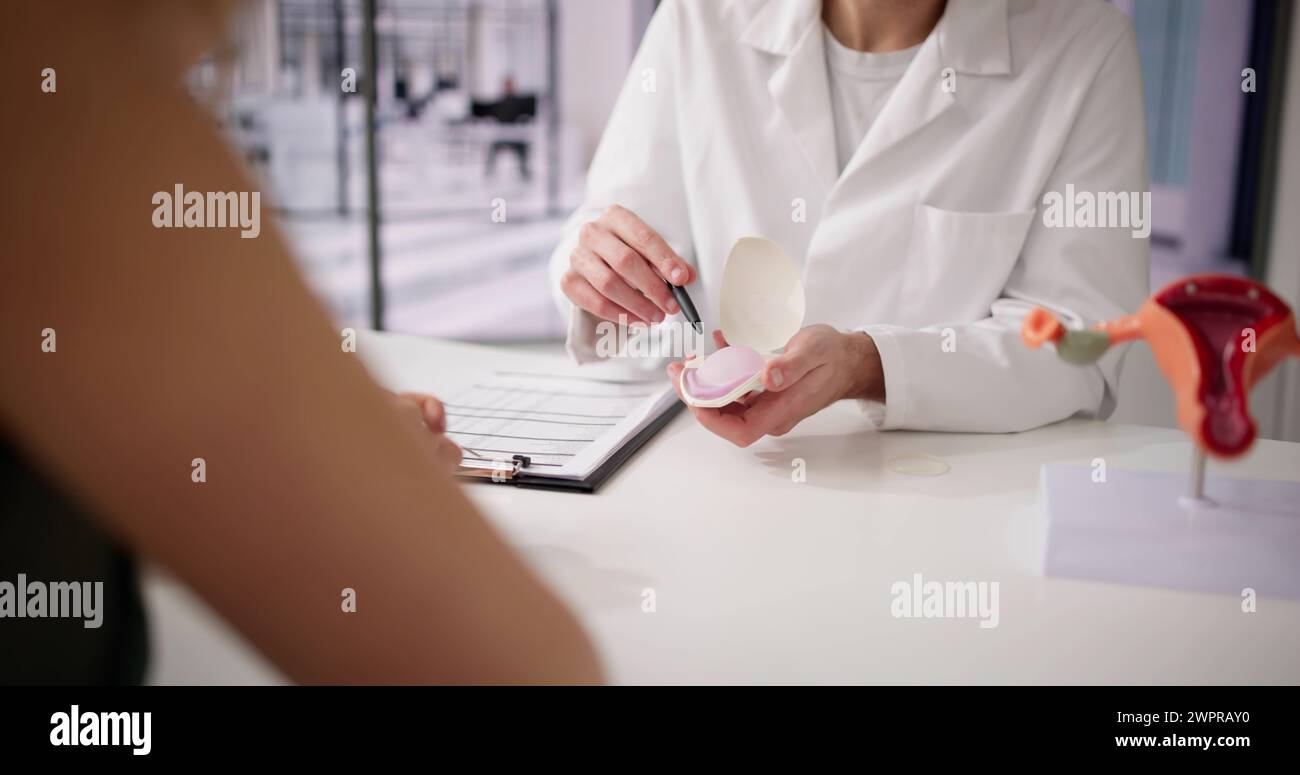 Gynecologist Showing Diaphragm To Woman And Explaining Birth Control Stock Photo
