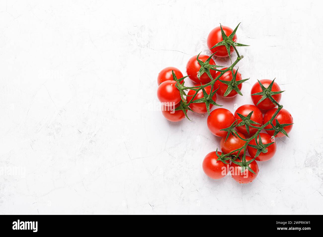 Cherry tomatoes on branches with copy space on white background, top view Stock Photo