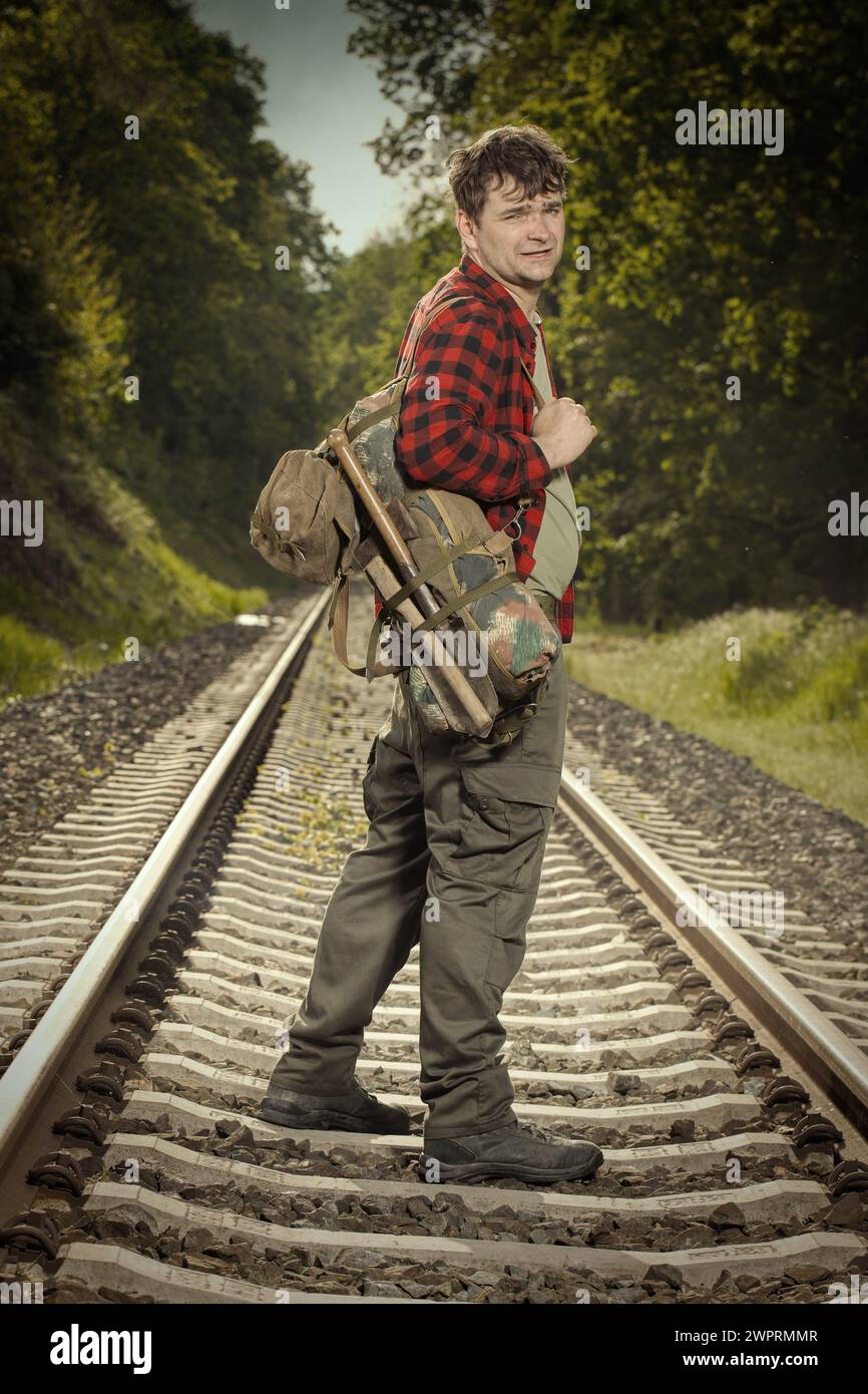 Adventurer with retro haversack wandering nature on railroad way Stock Photo