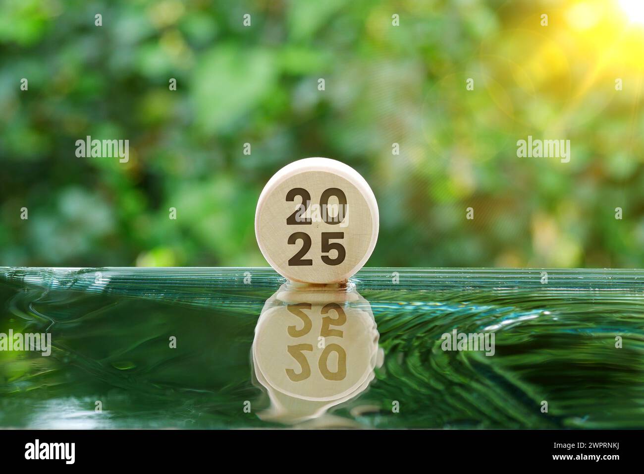 The year 2025 is carved on a log on the water with reflections Stock ...