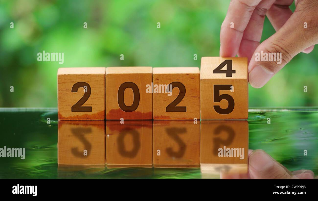 Hand flipping the year cube 2024 to 2025 Stock Photo Alamy