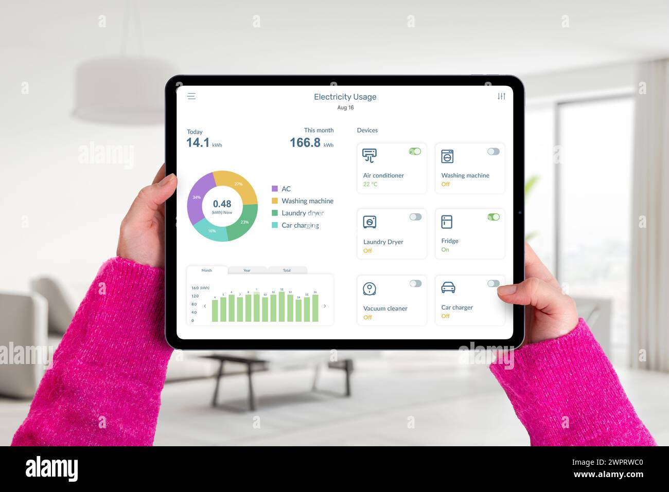 Hands hold tablet in living room with electricity usage app, monitoring consumption and controlling home devices. Concept of smart energy management Stock Photo