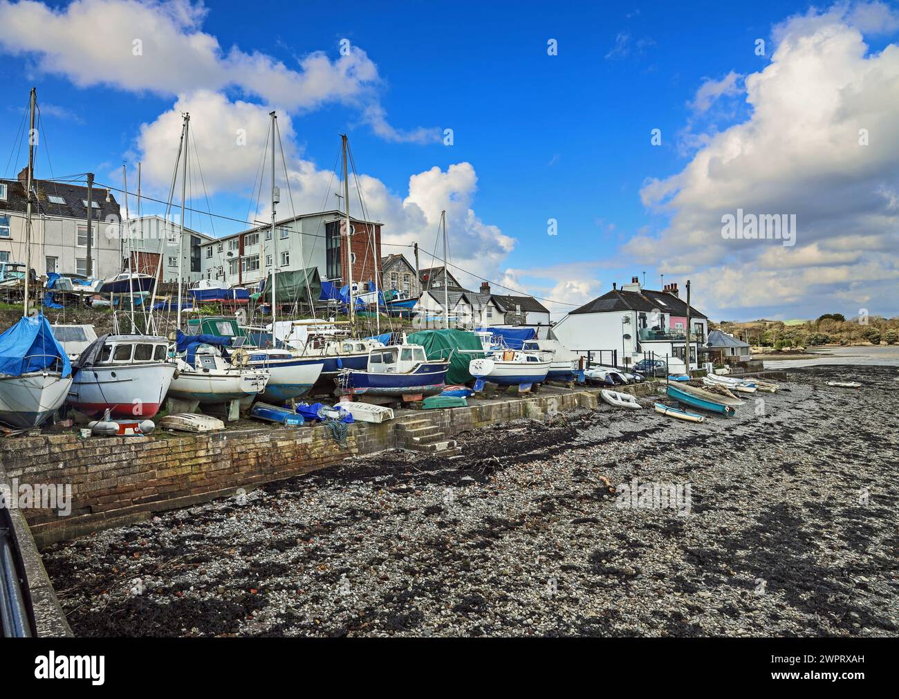 The riverside at Torpoint in south east Cornwall, with boats berthed on the harbour wall. Stock Photo