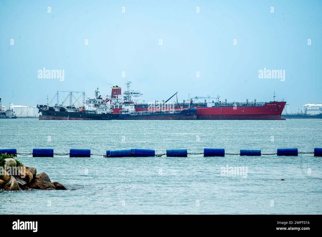Singapore, Singapore, 24 January 2024: Cargo ship and tankers on Singapore Strait daytime. Cargo ships anchored in road, waiting to enter busiest port Stock Photo