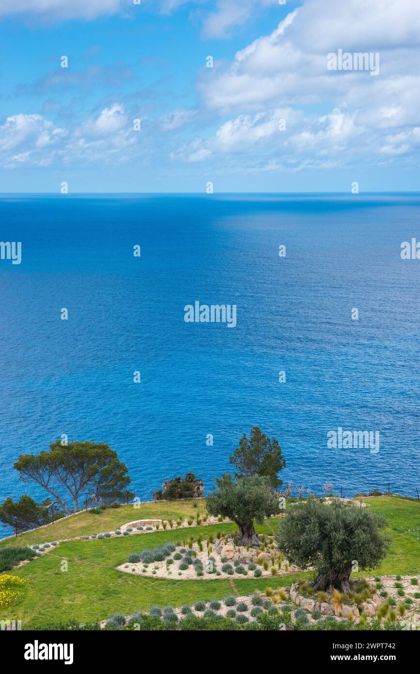 Peaceful sea view with terraced garden, green grass areas, rocky beds and trees in spring, rock garden with grasses, lavender (Lavandula), oleander Stock Photo