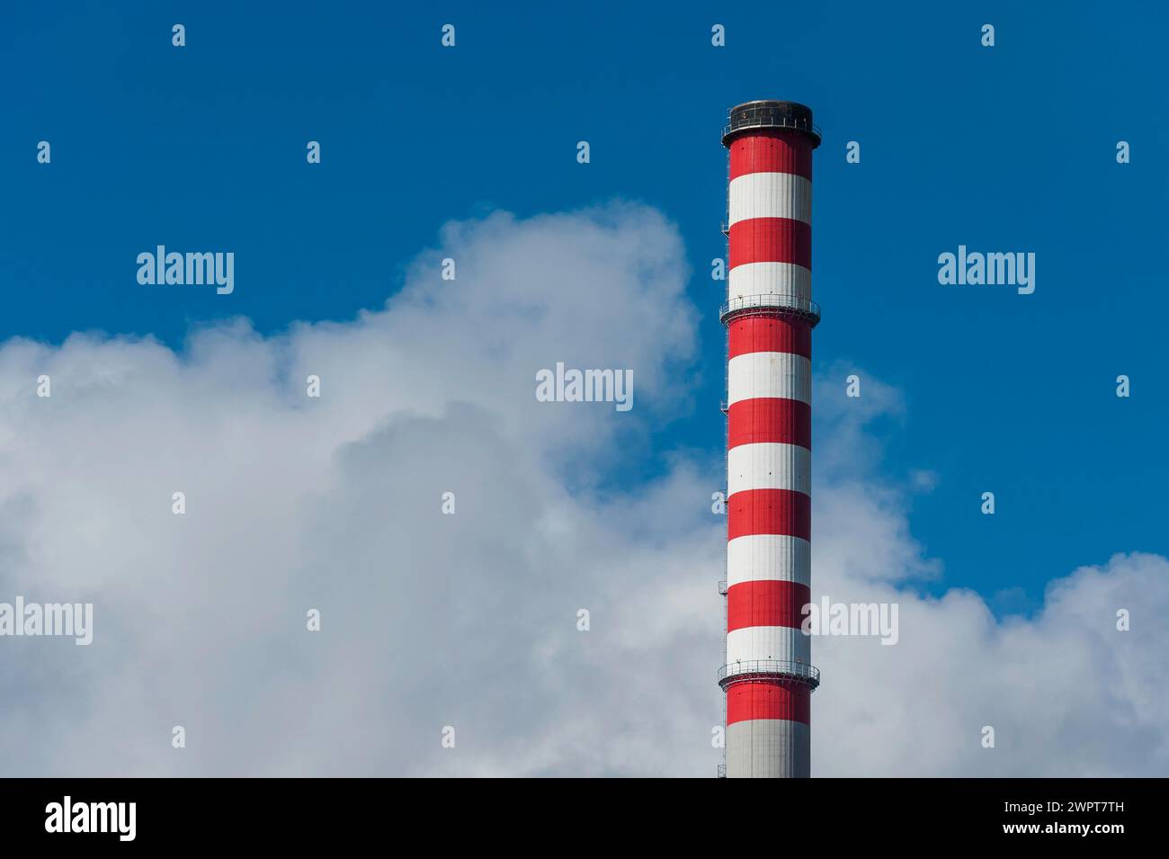 Chimney of a power plant in Sines, red, white, blue sky, power plant, energy, environment, climate, Co2, atmosphere, air pollution, exhaust fumes Stock Photo