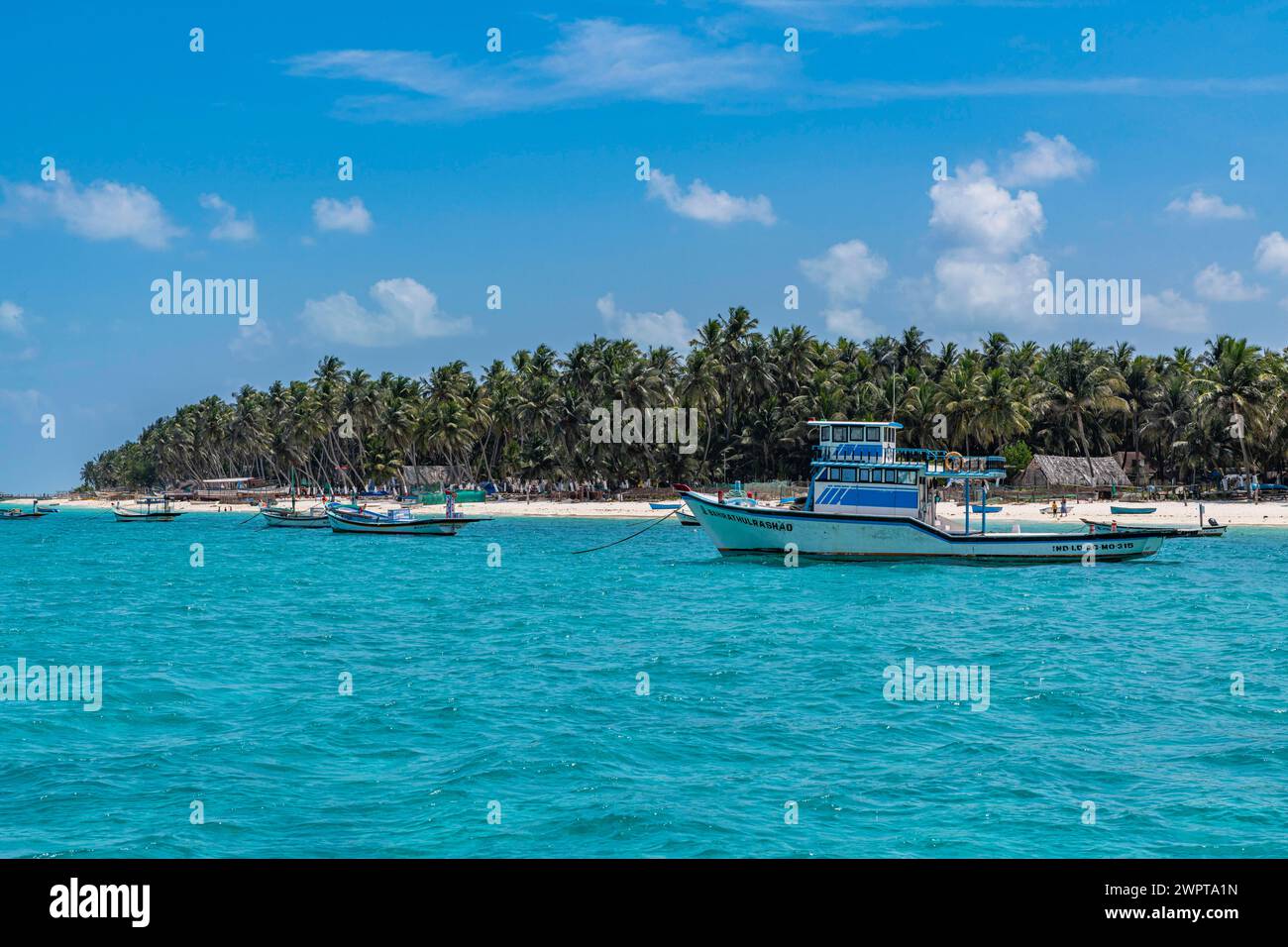 Little boats before a palm fringed white sand beach, Agatti Island, Lakshadweep archipelago, Union territory of India Stock Photo