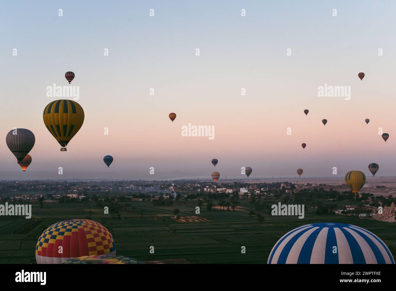 Wide view of dozens of hot air balloons flying around Luxor, Egypt Stock Photo