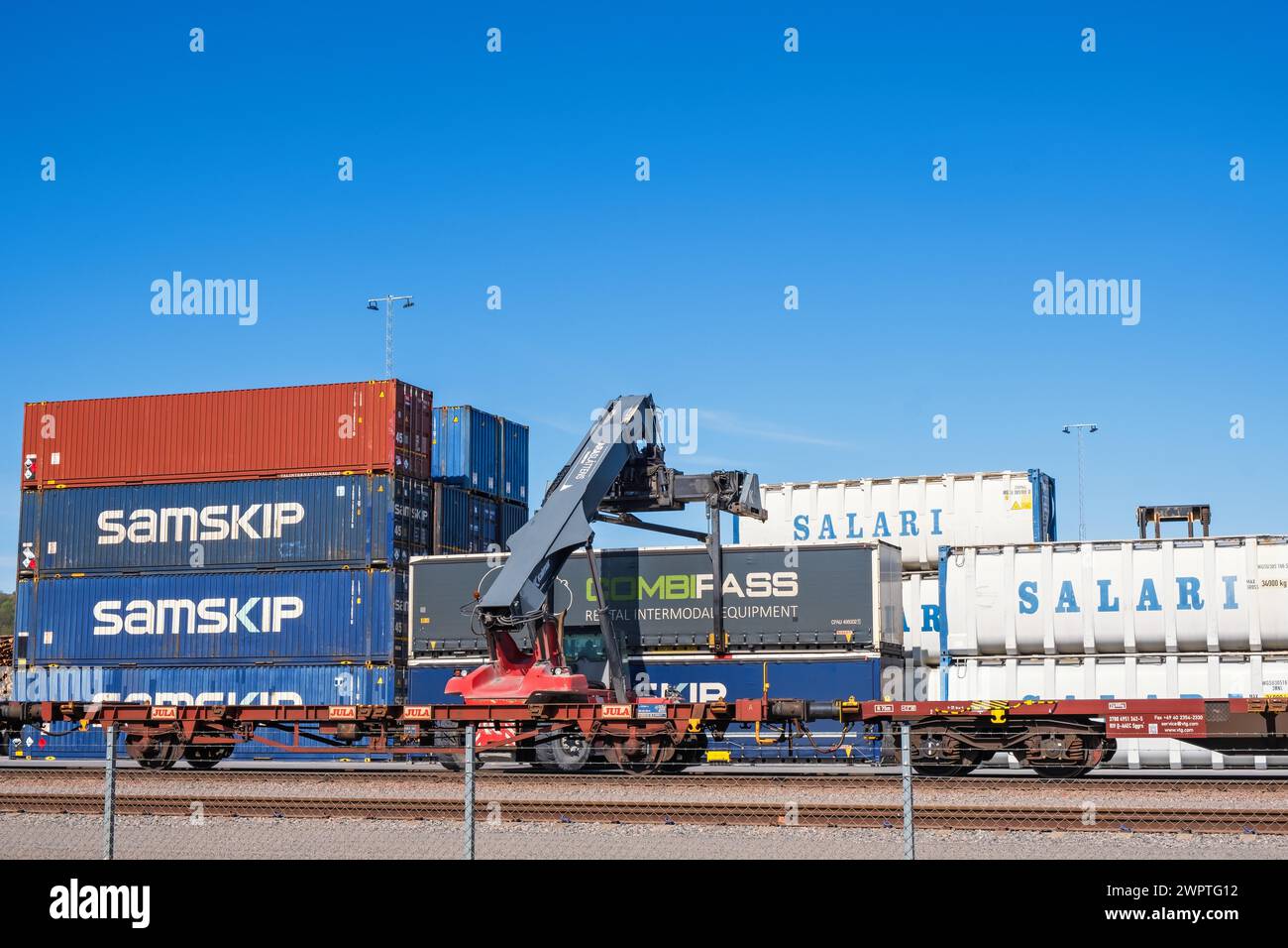 Loading of containers on railway wagons with a lifting crane at a ...