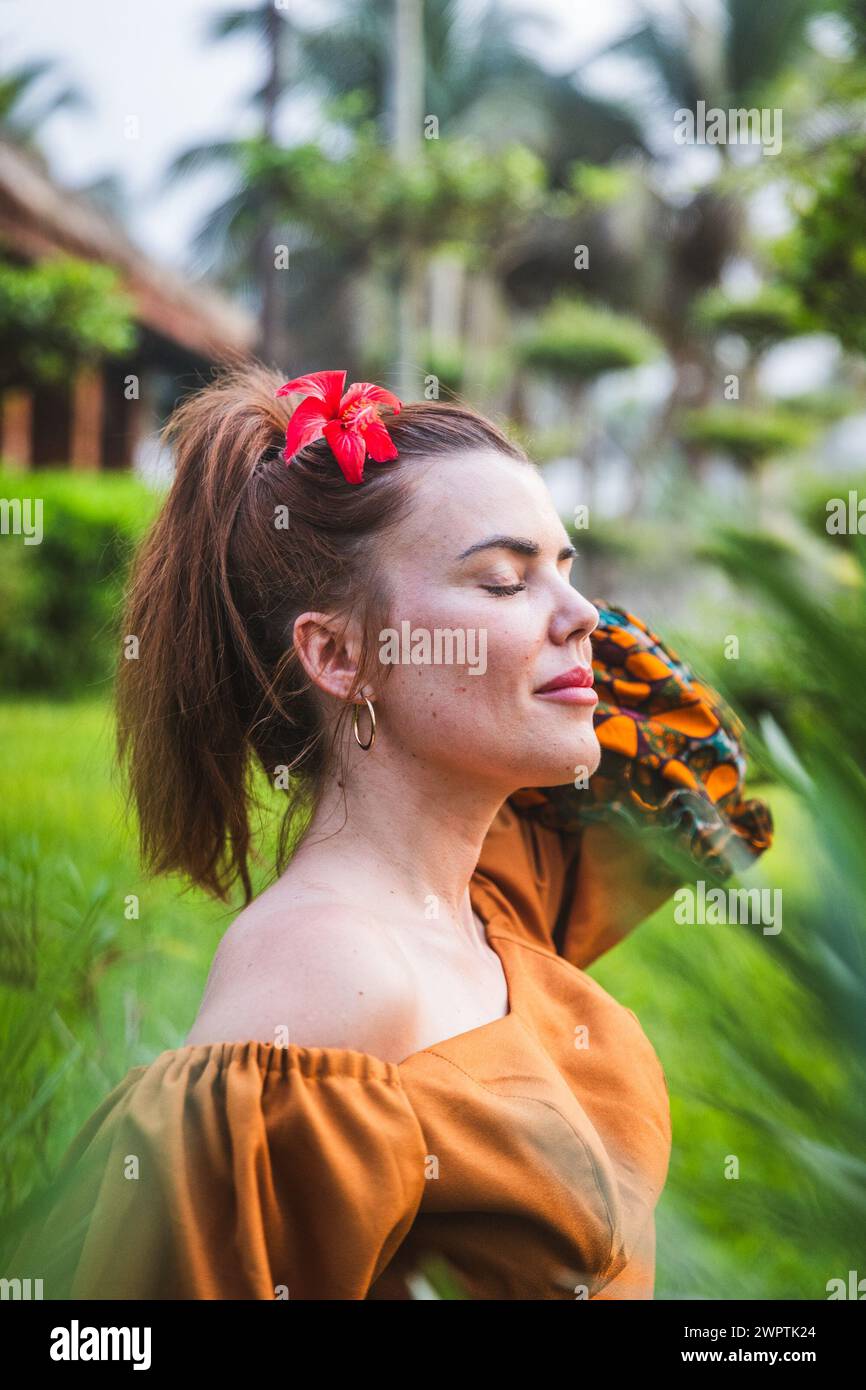 A girl with closed eyes breathes fresh air and meditates, vertical photo Stock Photo