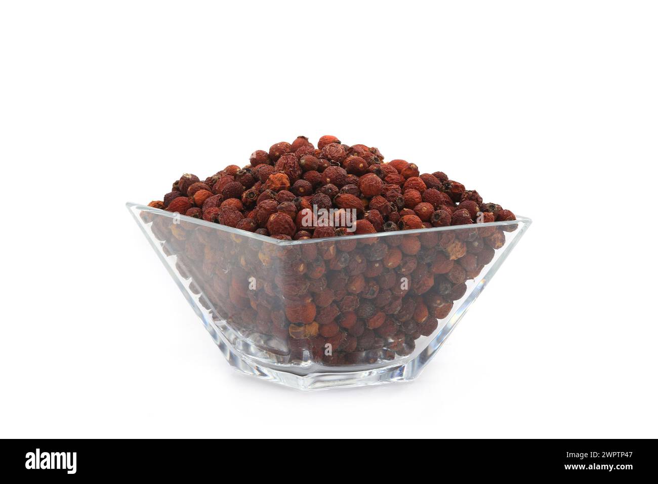 dry hawthorn berry in glass wares on a white background Stock Photo