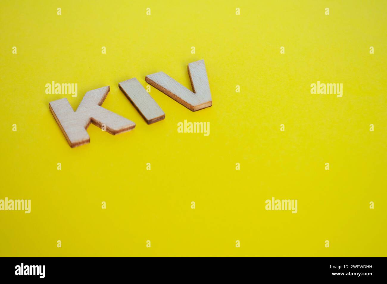 KIV wooden letters representing Keep In View on yellow background. Stock Photo