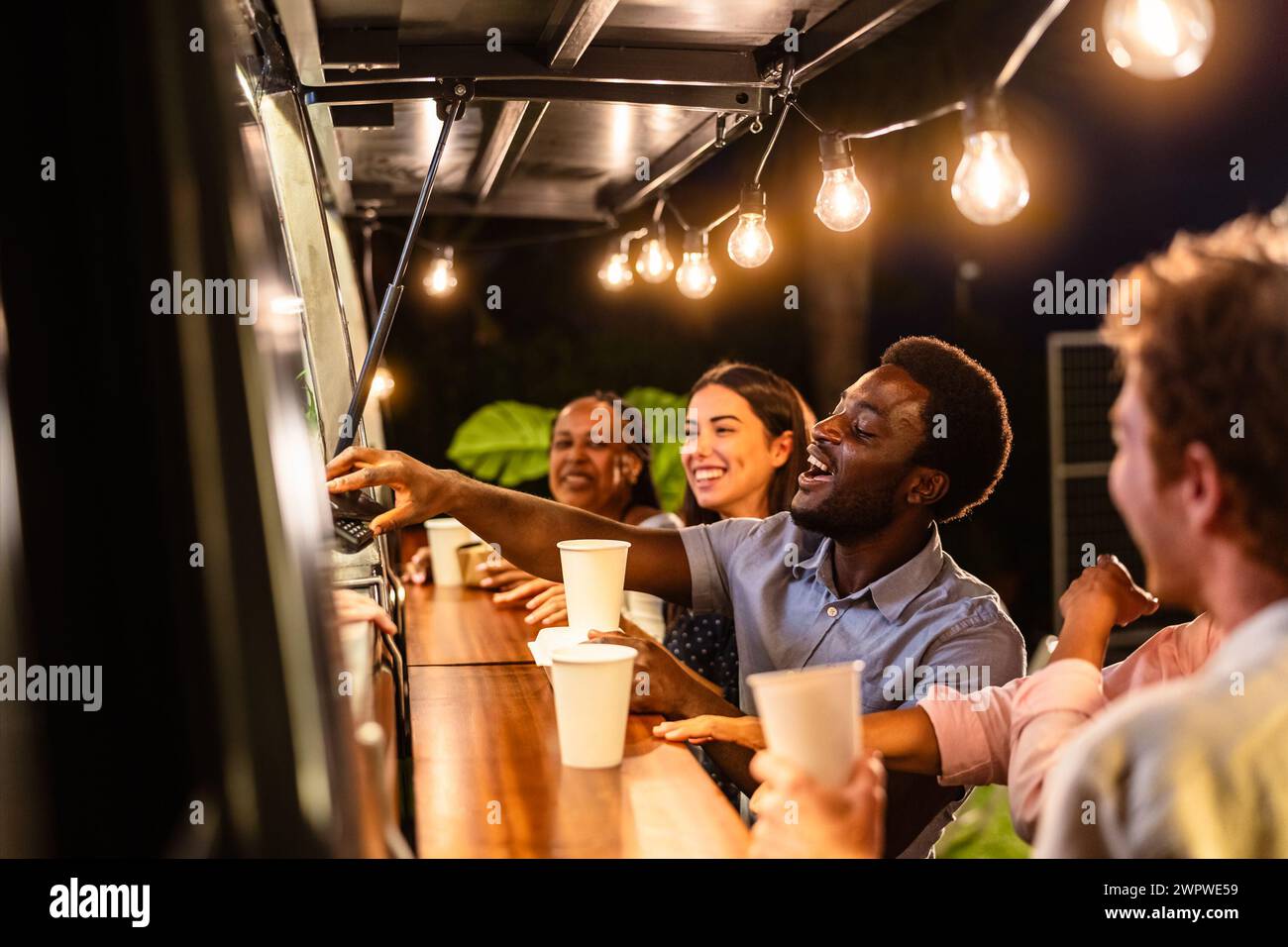 Happy multiracial people buying meal from food truck kitchen Stock Photo