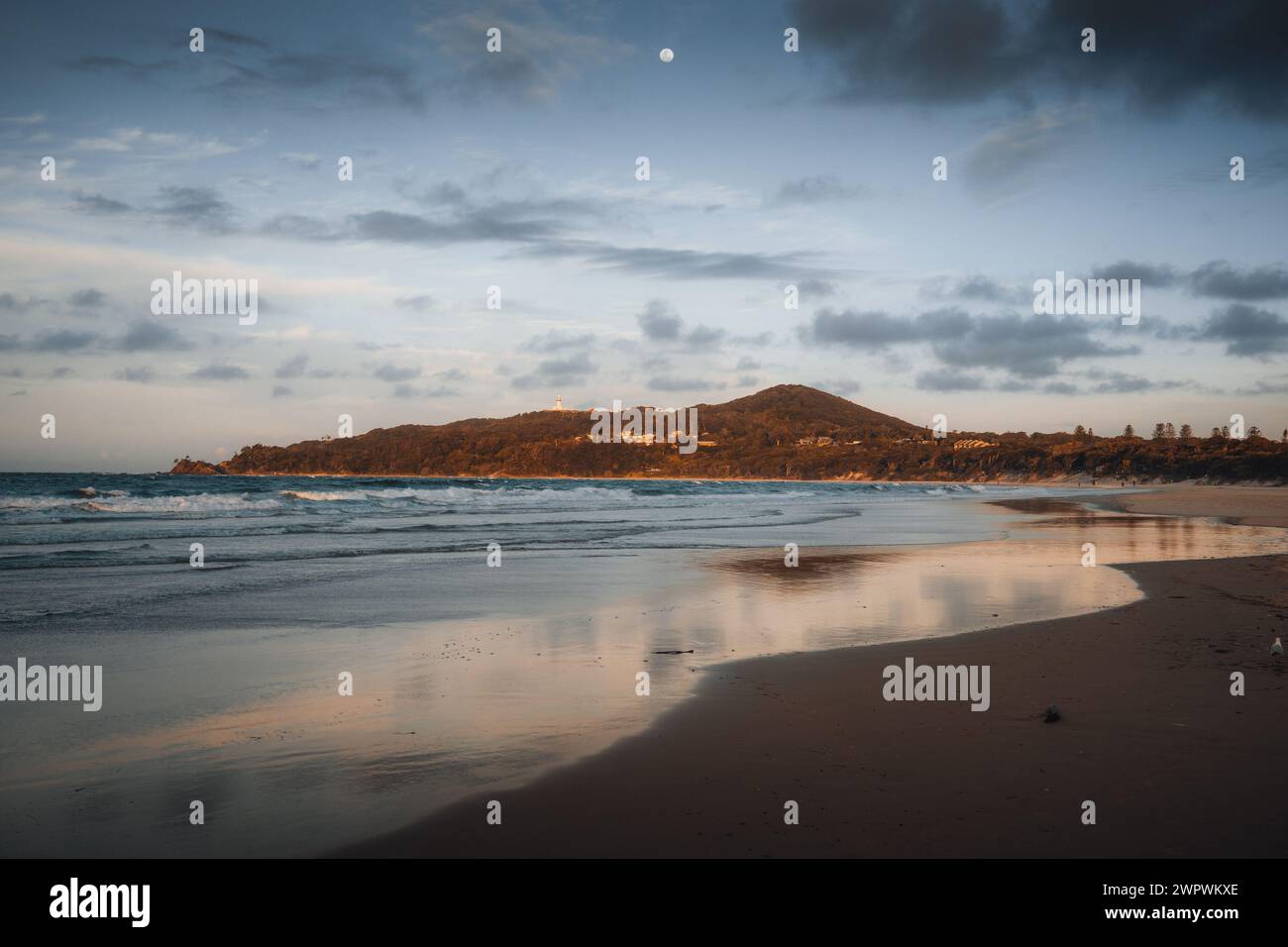 Byron Bay lighthouse high on the rocky headland - the most eastern point of Australian continent facing Pacific ocean in elevated aerial seascape Stock Photo