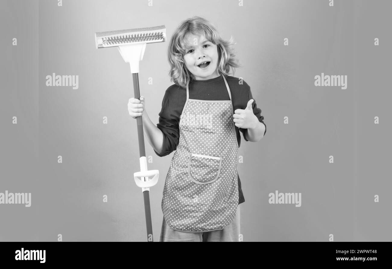 Child doing housework. Child use duster and gloves for cleaning. Funny child mopping house. Cleaning accessory, cleaning supplies. Housekeeping and Stock Photo