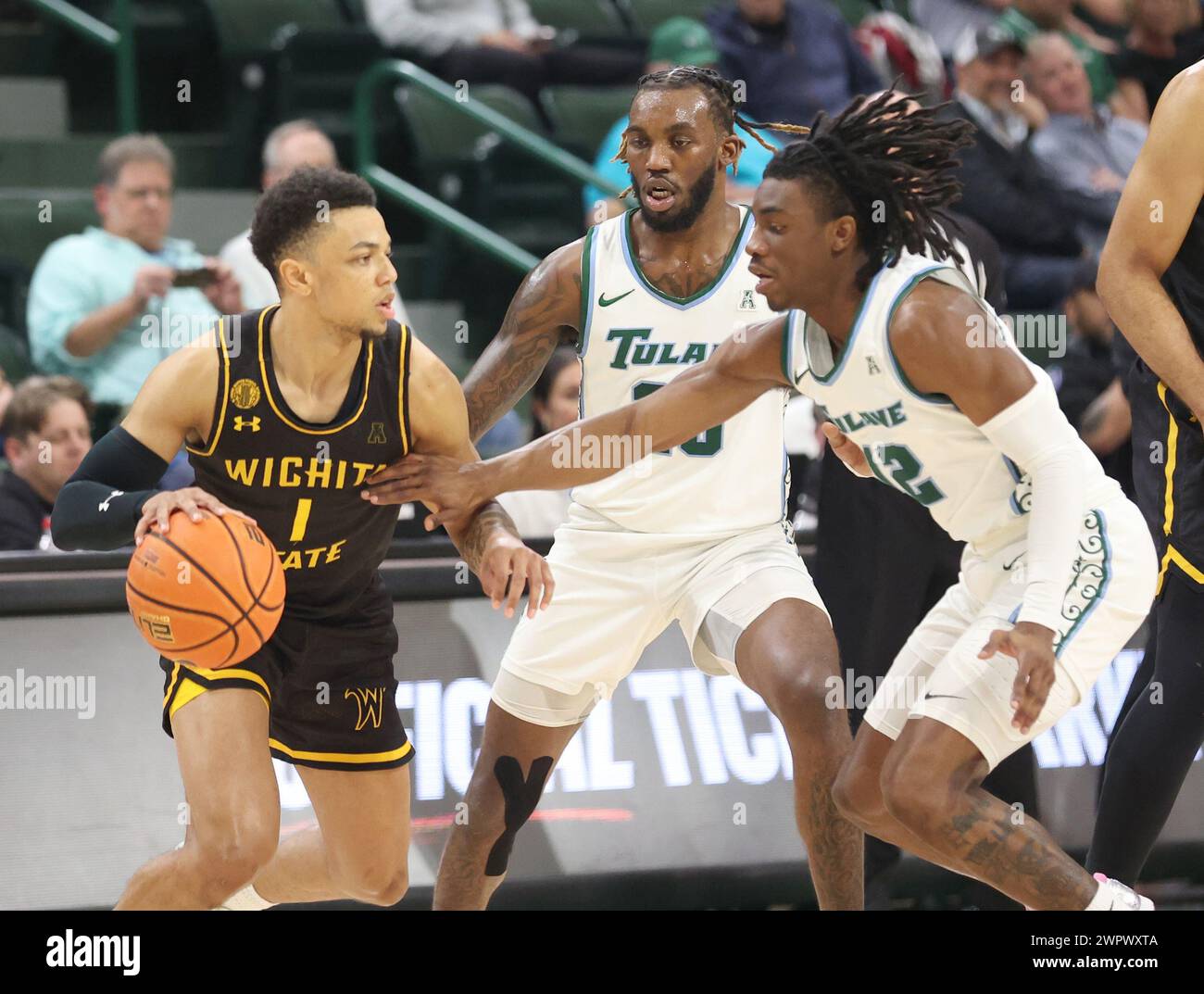 New Orleans, USA. 08th Mar, 2024. Wichita State Shockers guard Xavier Bell (1) tries to get past Tulane Green Wave guards Jaylen Forbes (25) and Kolby King (12) during an American Athletic Conference men's basketball game at Fogleman Arena in New Orleans, Louisiana on Friday, March 8, 2024. (Photo by Peter G. Forest/Sipa USA) Credit: Sipa USA/Alamy Live News Stock Photo