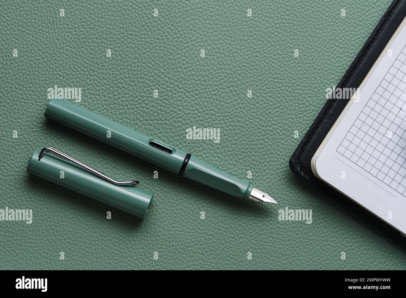 Fountain pen and notebook green leather background Stock Photo