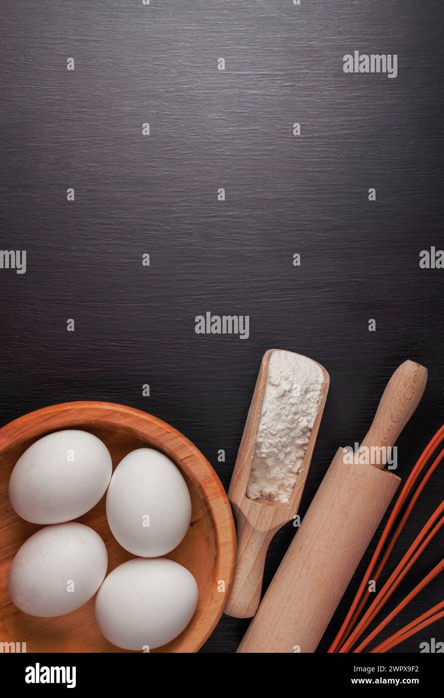 Baking background with ingredients for making gingerbread : flour, eggs, kitchen tools, utensils and on dark wooden table. Top view. Flat lay style. M Stock Photo