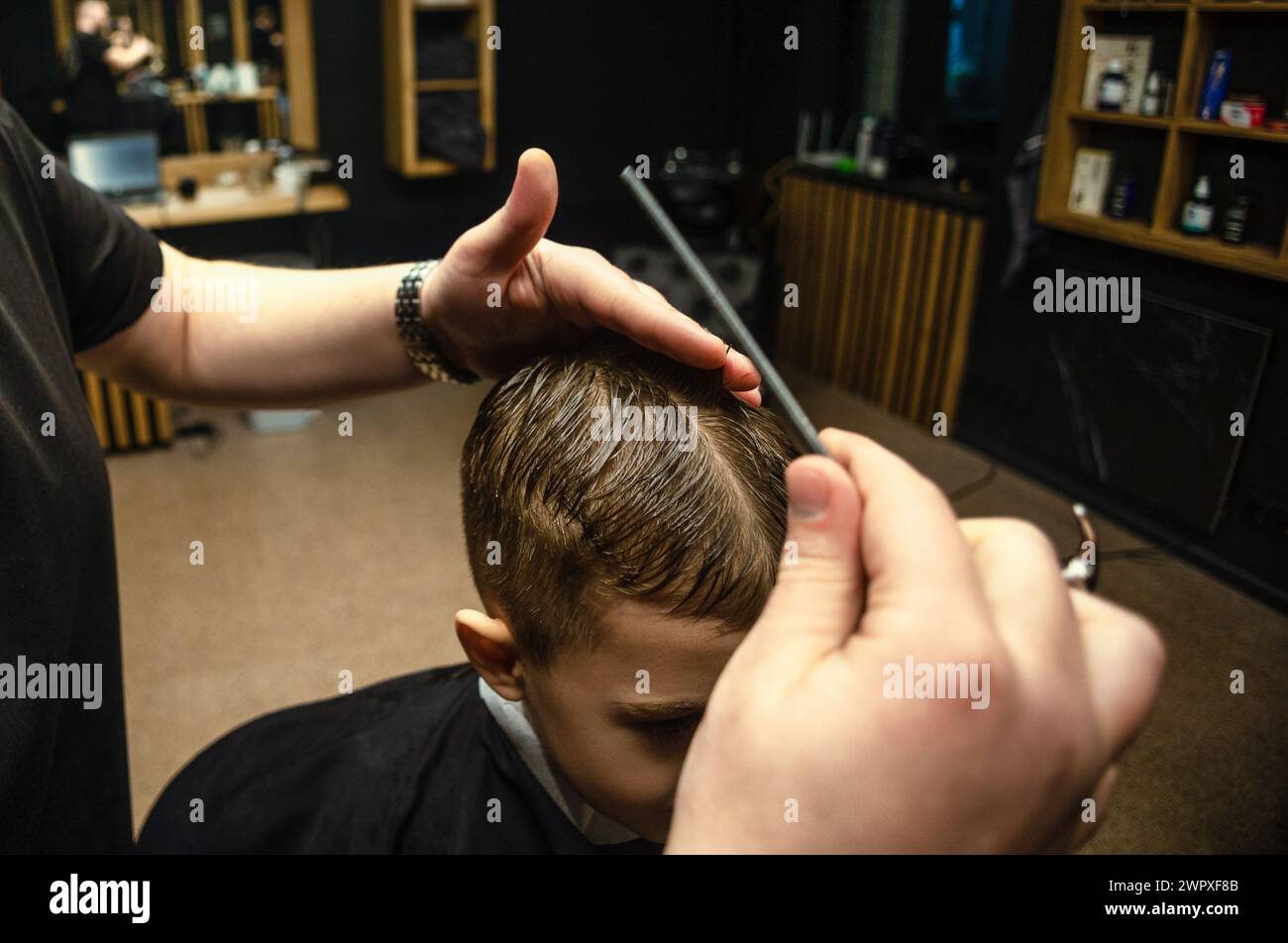children's haircut with scissors in a barbershop Stock Photo