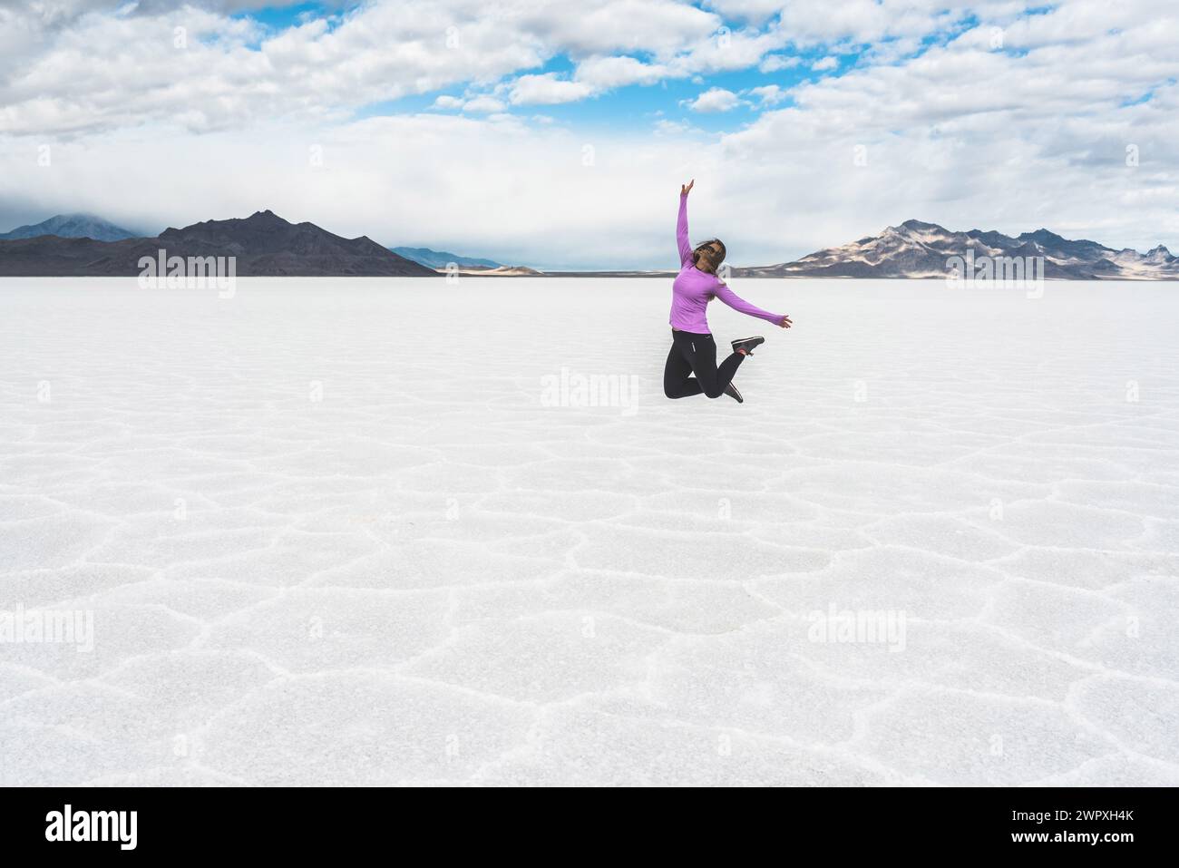 Woman jumping on the Bonneville Salt Flats in Utah Stock Photo