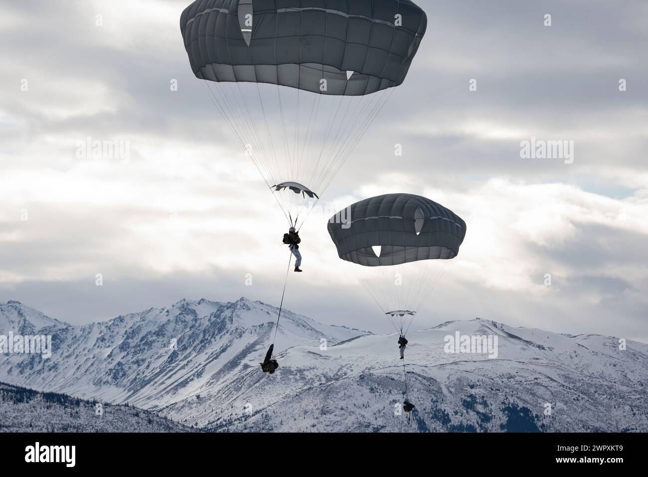 Female U.S. Army paratroopers with the 2nd Infantry Brigade Combat Team, 11th Airborne Division “Arctic Angels” jump from a C-17 Globemaster III Stock Photo