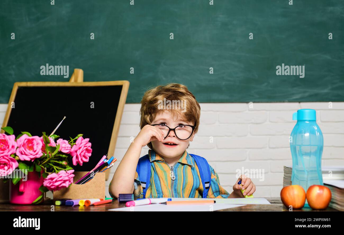 Portrait of cute elementary school pupil in classroom. Little schoolboy ...