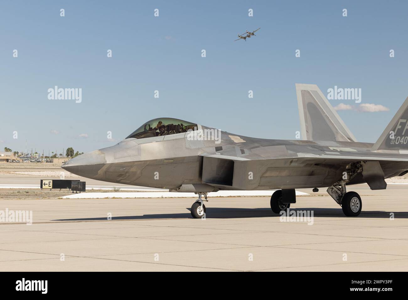 A U.S. Air Force (USAF) F-22 Raptor pilot with the USAF F-22 Raptor demo team, waves to the audience during the Airshow Children’s Expo at Marine Corps Air Station Yuma, Arizona, March 8, 2024. The event featured performances of military aircraft and ground equipment as well as educational career displays that allowed children with special needs to enjoy the Yuma Airshow 2024 in a controlled environment. (U.S. Marine Corps photo by Cpl. Jade K. Venegas) Stock Photo