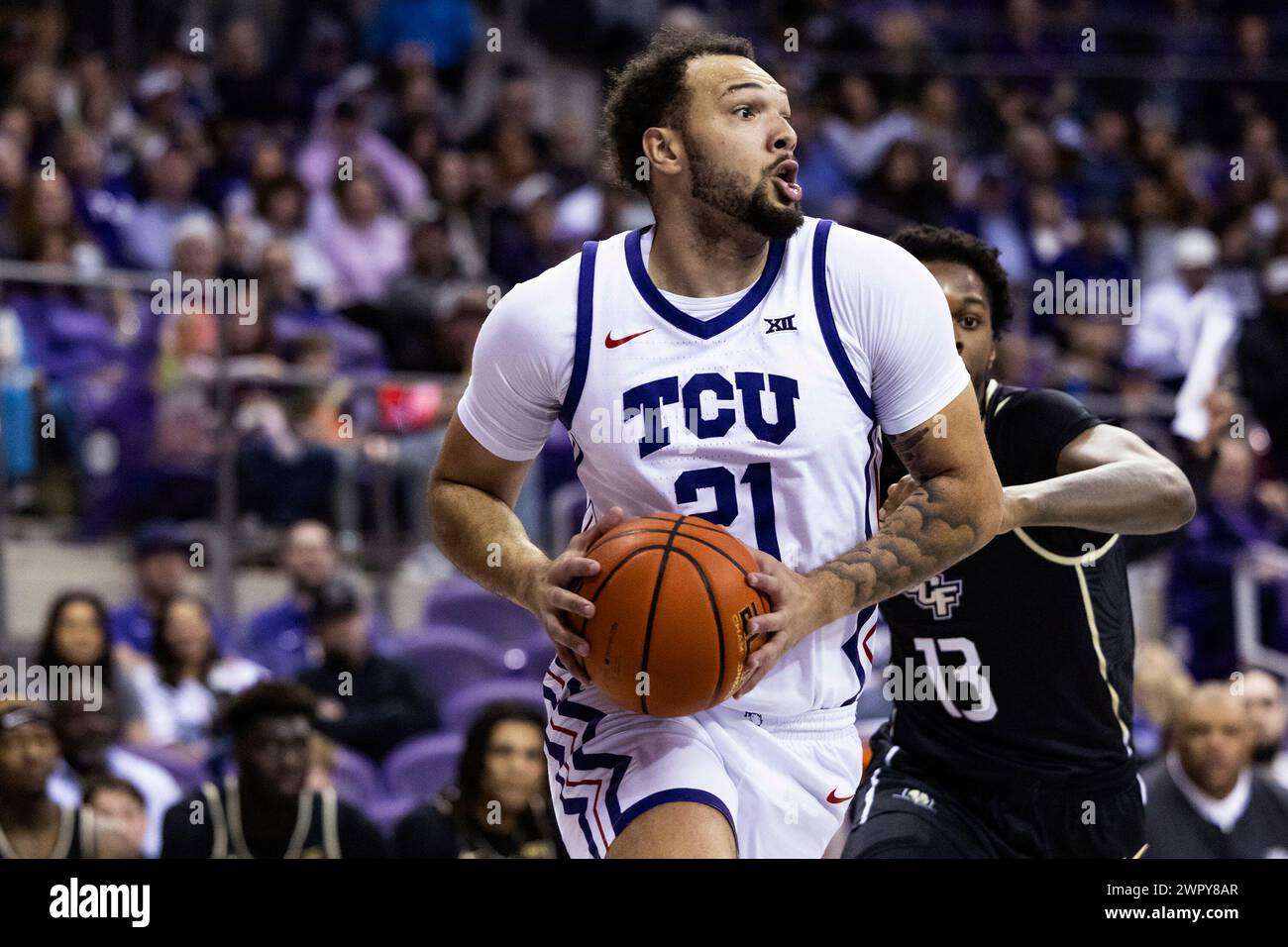 TCU forward JaKobe Coles (21) drives to the basket in front of Central