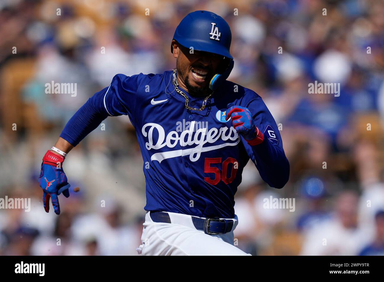 Los Angeles Dodgers' Mookie Betts runs to first base after hitting a