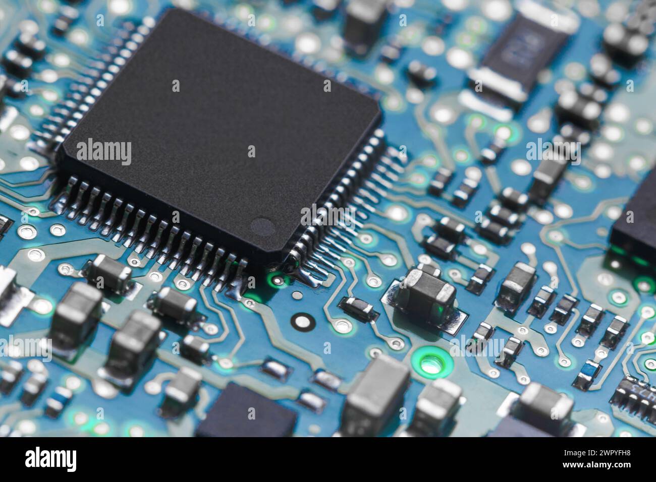 A close-up of a printed circuit board with a processor and various elements in backlight. Stock Photo