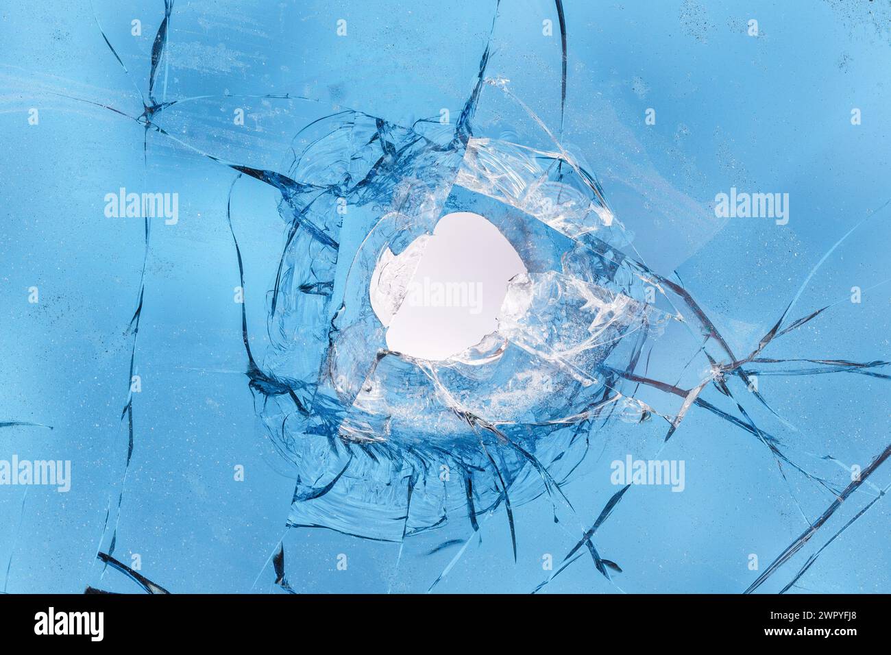 A bullet hole in a car's tinted glass close-up Stock Photo - Alamy