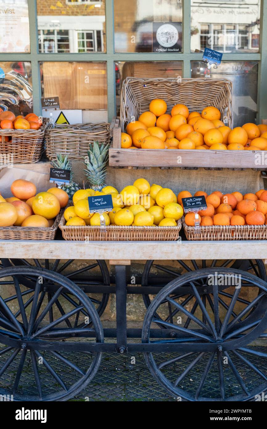 Oranges, lemons, grapefruit for sale on a cart outside Eagles Fine Foods shop. Deddington, Oxfordshire, England Stock Photo
