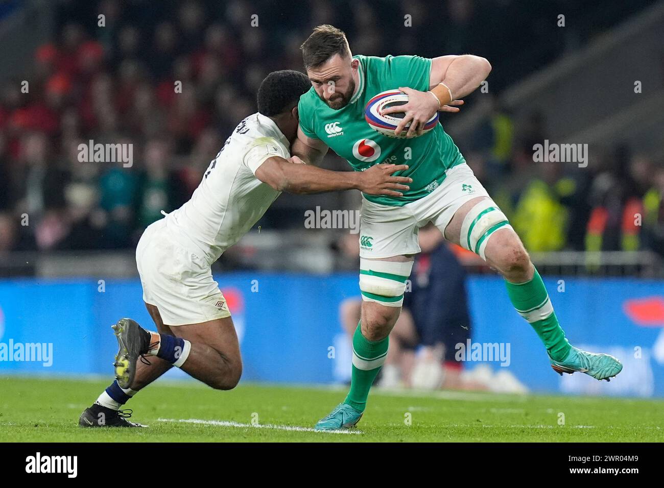 Jack Conan of Ireland hands off Immanuel Feyi-Waboso of England during ...