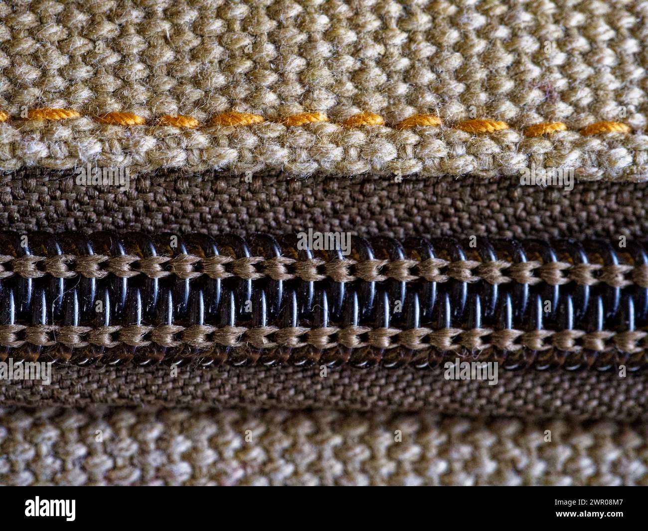 A close-up of fabric with a zipper, showing detailed stitching and texture. Stock Photo