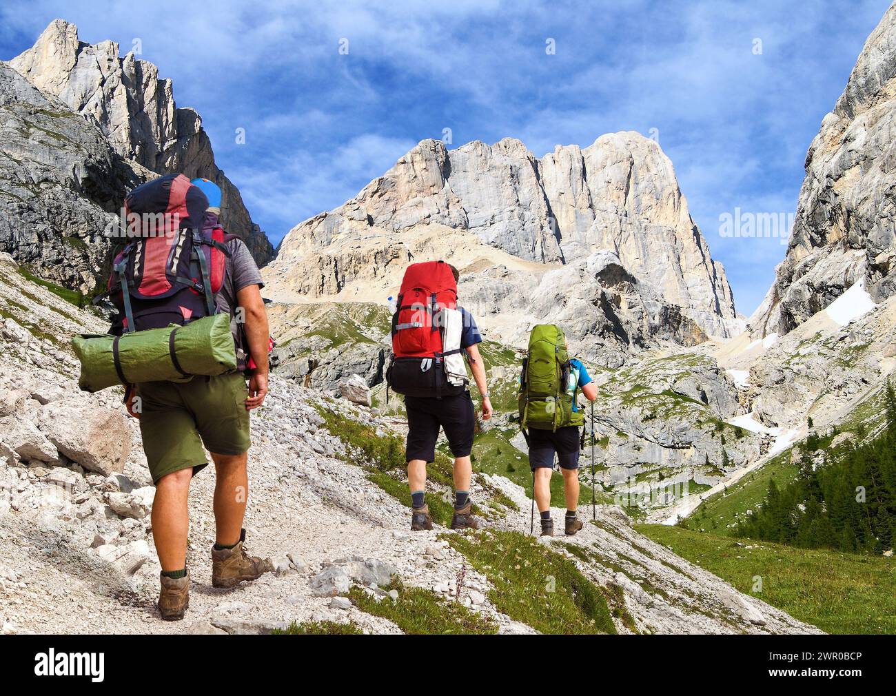 Montage of three hikers and southern side of mount marmolada, Alps ...