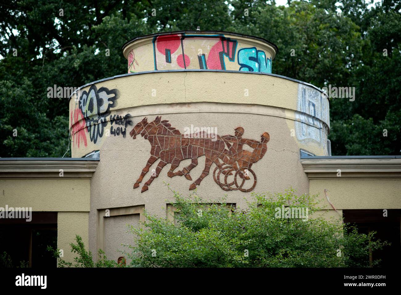 Karlshorst, Trabrennen DEU, Deutschland, Germany, Berlin, 30.07.2023 Eingang der Trabrennbahn Karlshorst am Renntag im Pferdesportpark an der Treskowallee im Bezirk Lichtenberg in Berlin Deutschland . Die Traditionelle Pferderennbahn im Trabsport verstroemt aufgrund des alten Erhaltungszustand bis heute den sproeden Charme der ehemaligen DDR und wird im Gegensatz zu den Besuchern im Galoppsport eher von Rentner und Wettbegeisterten besucht. en: Entrance of the Karlshorst trotting course on the day of the race in the equestrian sports park on Treskowallee in the district of Lichtenberg in Berli Stock Photo