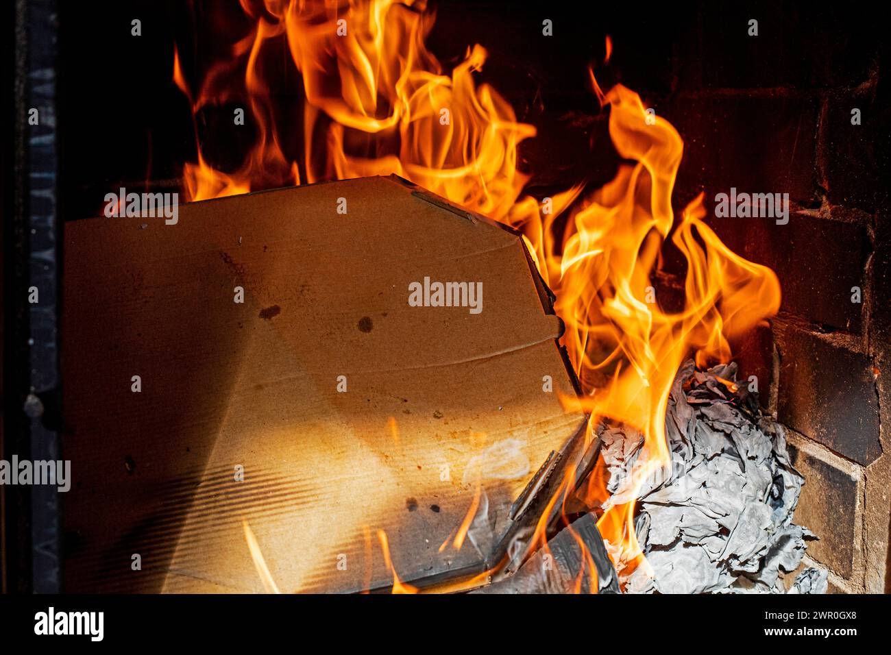 burning pizza boxes indoors on a dark background. . Ecological catastrophy Stock Photo