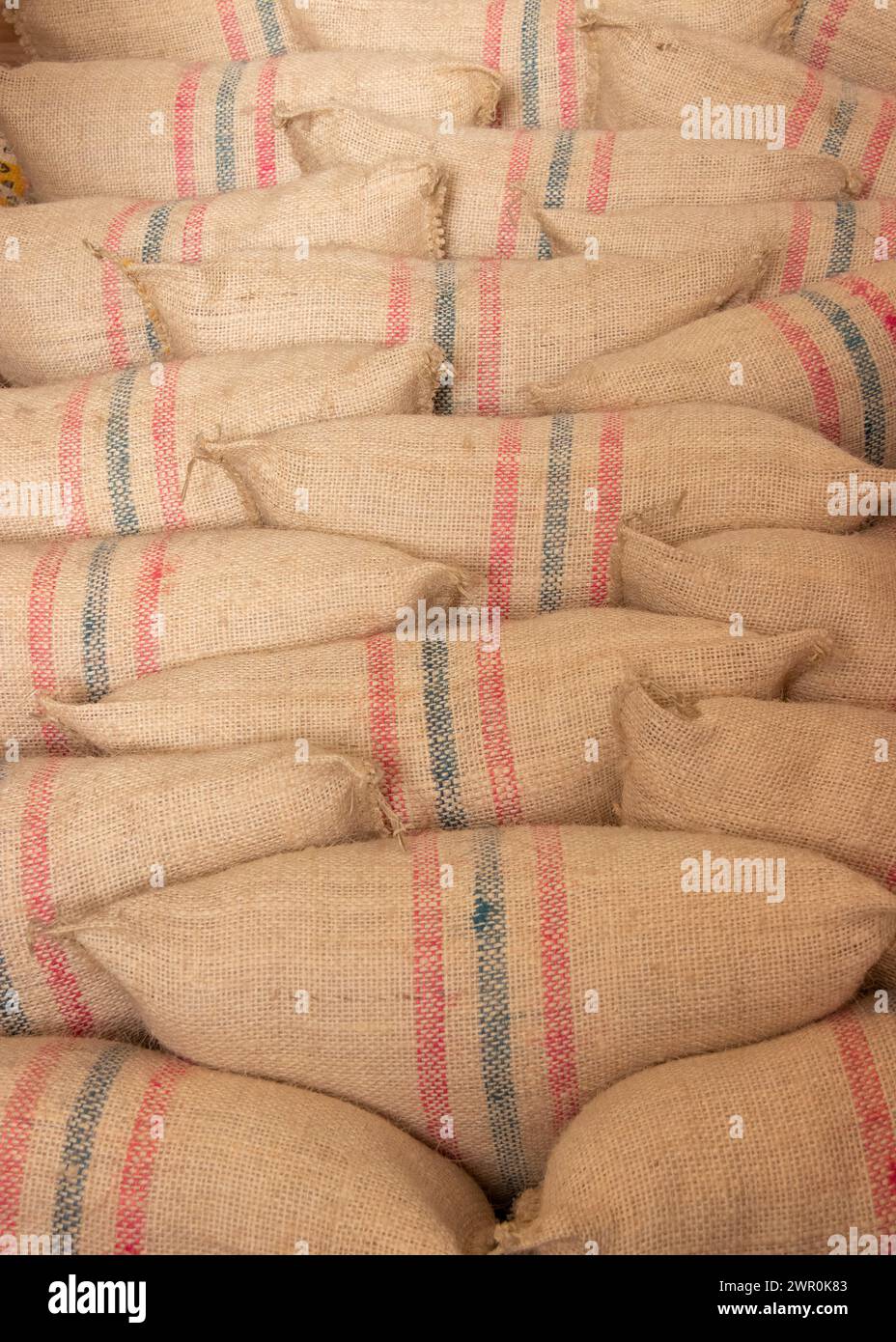 brown hessian woven coffee sacks piled u[ and filled with coffee ready for sale and export from Columbia Stock Photo