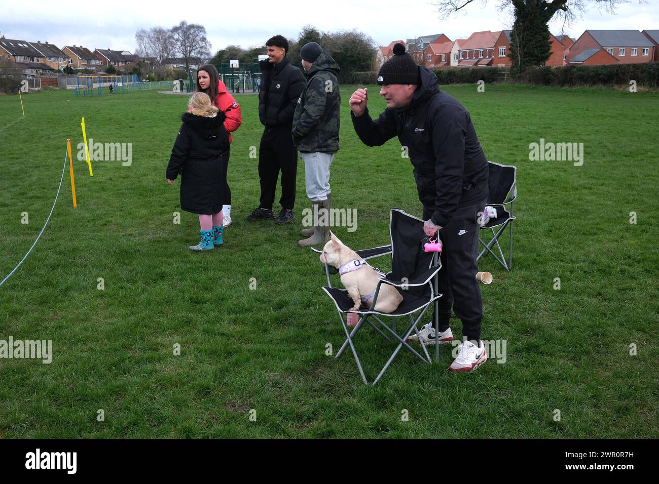 Man and his pet dog watching junior football match. Stock Photo