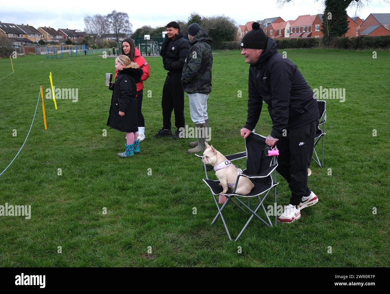 Man and his pet dog watching junior football match. Stock Photo