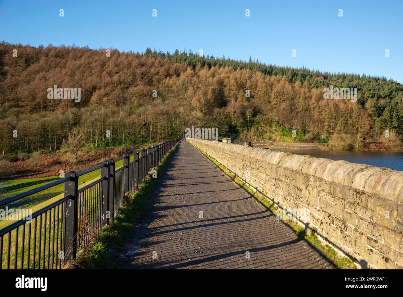 Footpath along Ladybower Dam in the Derwent Valley, Peak District national park, Derbyshire on a sunny winter day. Stock Photo