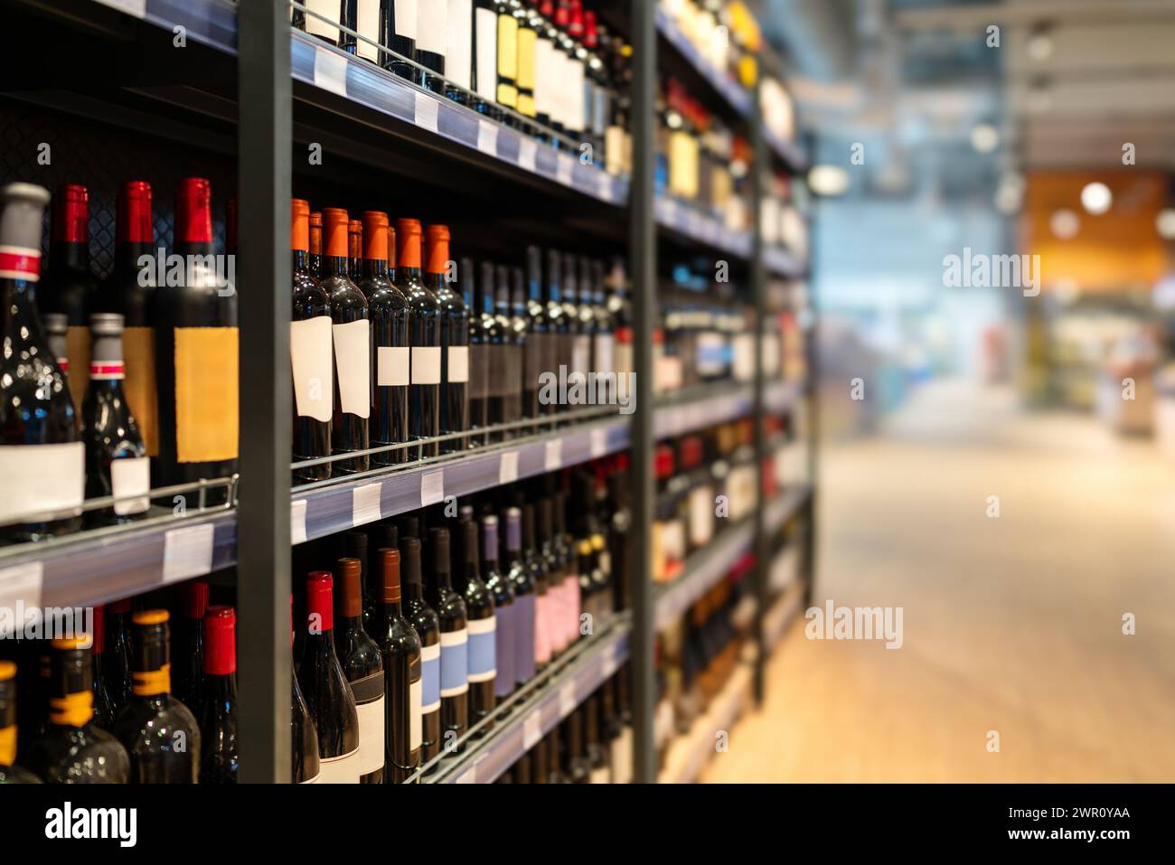 Liquor store concept. Wine bottles on shelves in the wine shop. Stock Photo