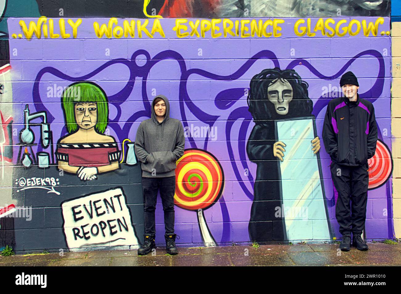 Glasgow, Scotland, UK. 10th March, 2024: Willy’s Chocolate Experience   Fan Kai and his friend descended to the artwork on the banks  of the river clyde. Willy Wonka debacle mural appeared on the clyde side graffiti wall on the clyde walkway. The painting was created by artist Ejek after the  film experience event became national news. The artwork depicts the actresses who worked at the event as an Oompa Loompa and 'The Unknown'from the artificial intelligence script.  Credit Gerard Ferry/Alamy Live News Stock Photo