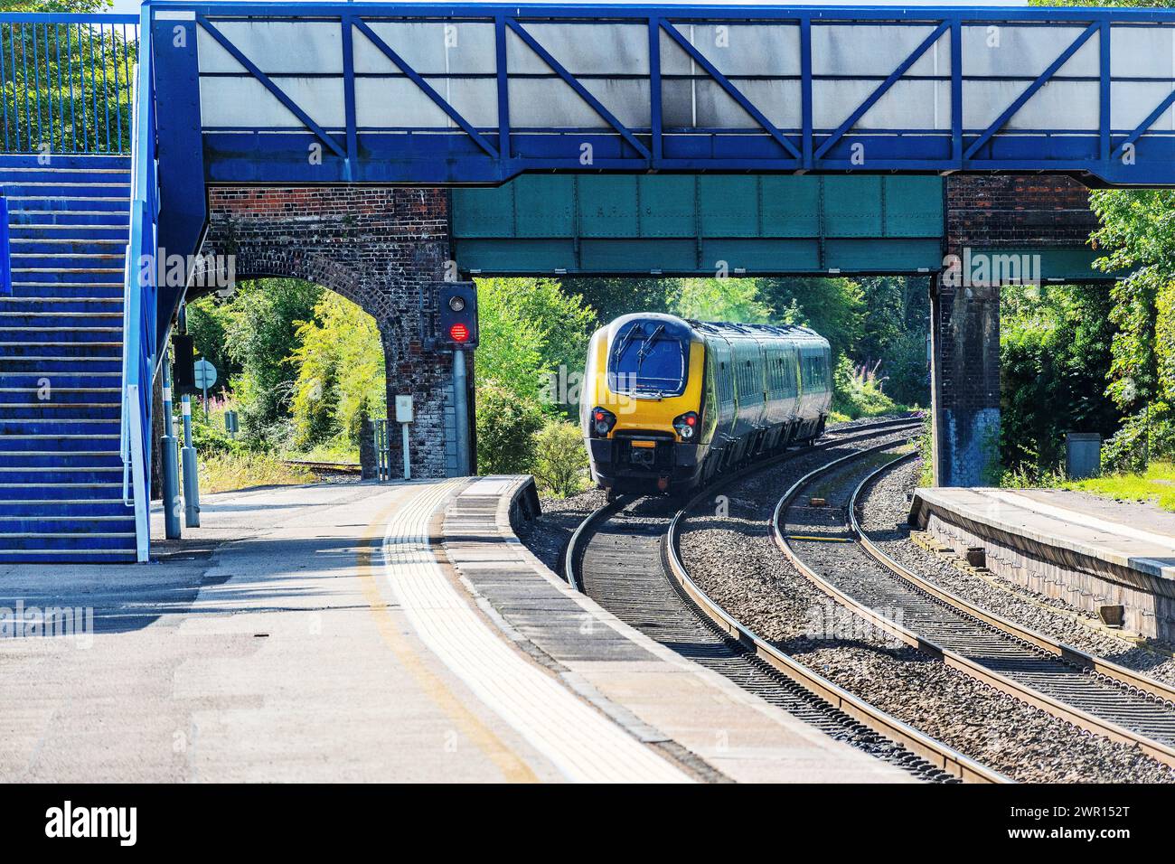 Express passenger train passing through commuter station west midlands england uk Stock Photo